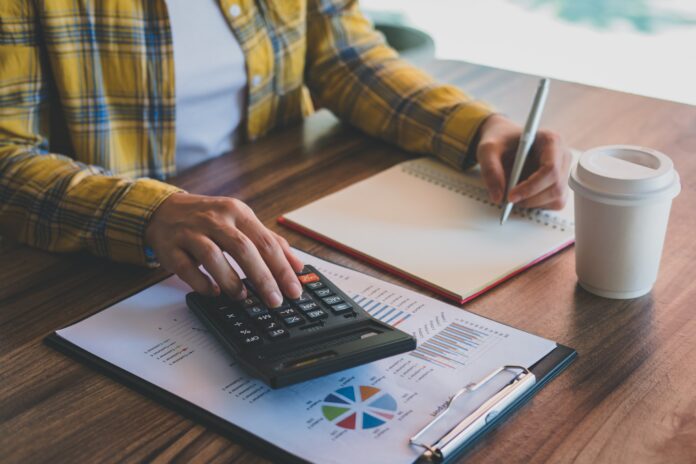 business-woman-using-calculator-with-analysis-charts-graphs-business-report-writing-notebook-office.jpg פריפיק